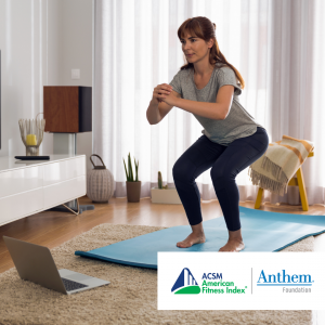 woman doing squats in living room in front of an open laptop