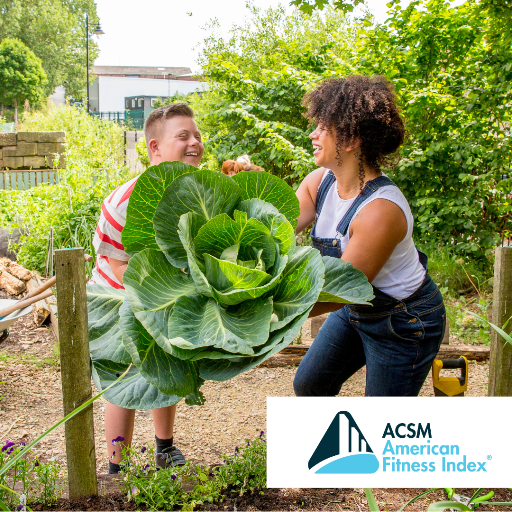 woman wearing overalls and young boy in striped shirt harvesting a giant lettuce in a community garden